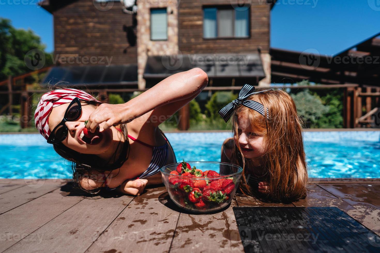 duas meninas na beira da piscina foto