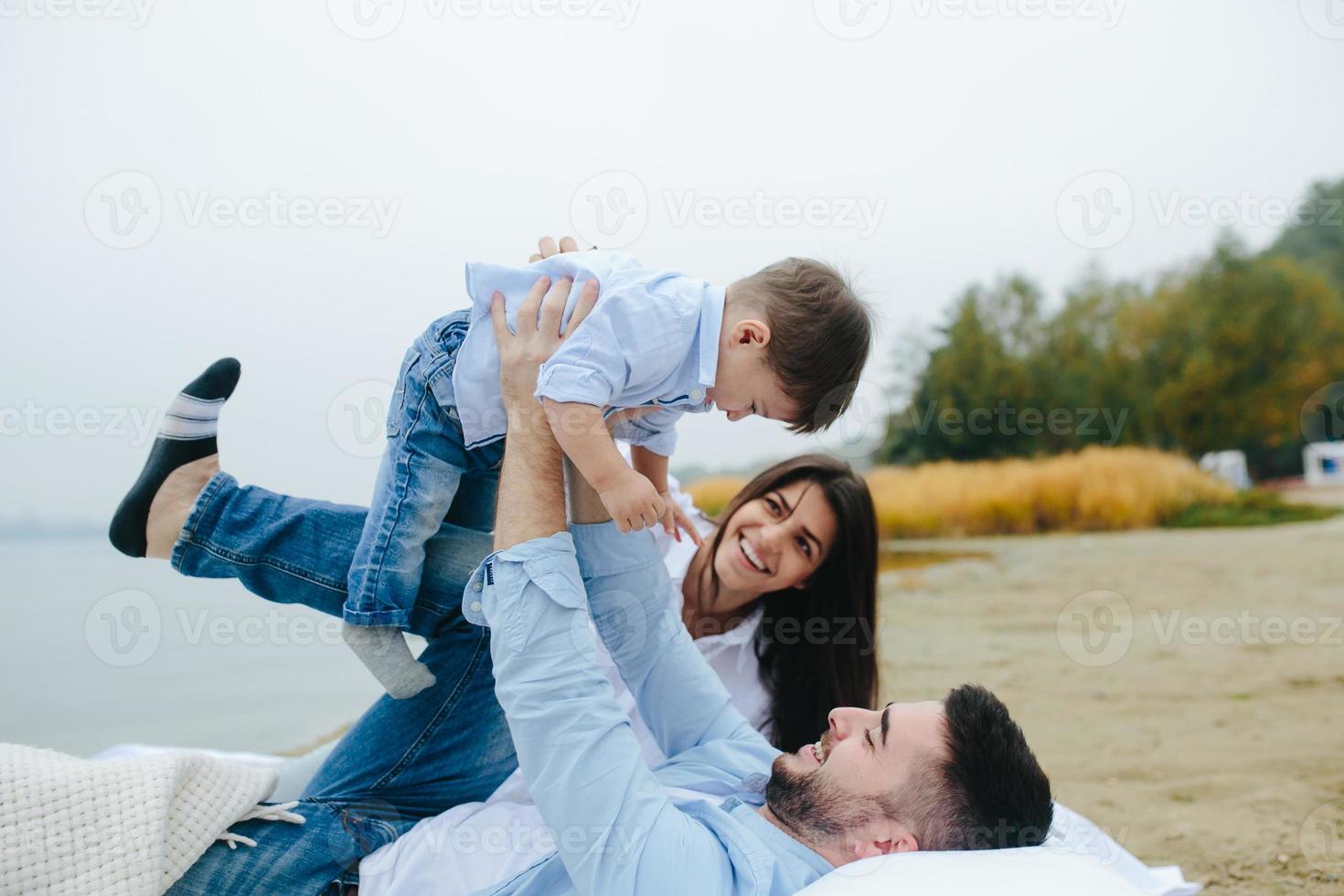 família jovem feliz relaxando juntos no lago foto