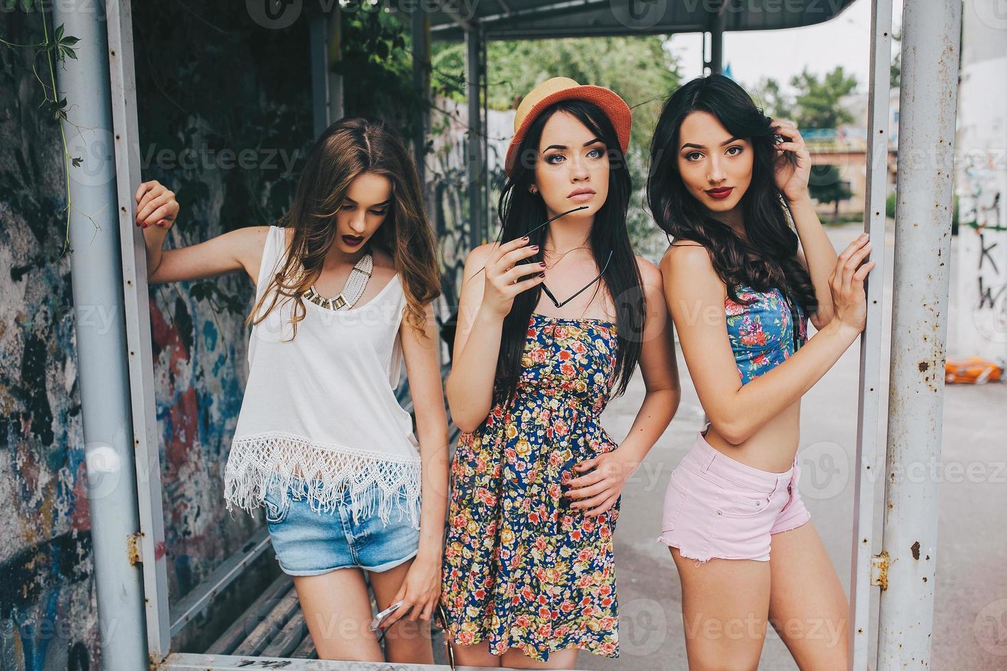 três lindas meninas no ponto de ônibus foto