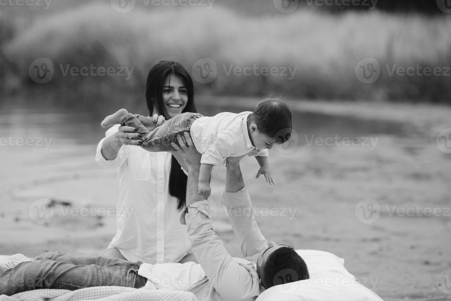 família jovem feliz relaxando juntos no lago foto