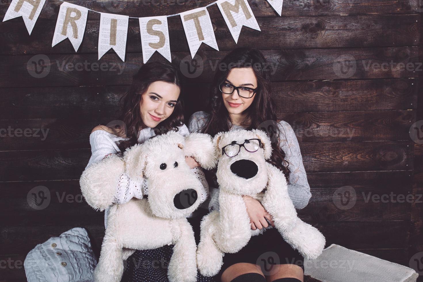 duas garotas encantadoras brincando com brinquedos de natal foto