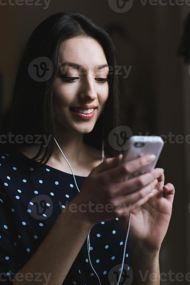 menina bonita, ouvindo música no telefone com fones de ouvido foto