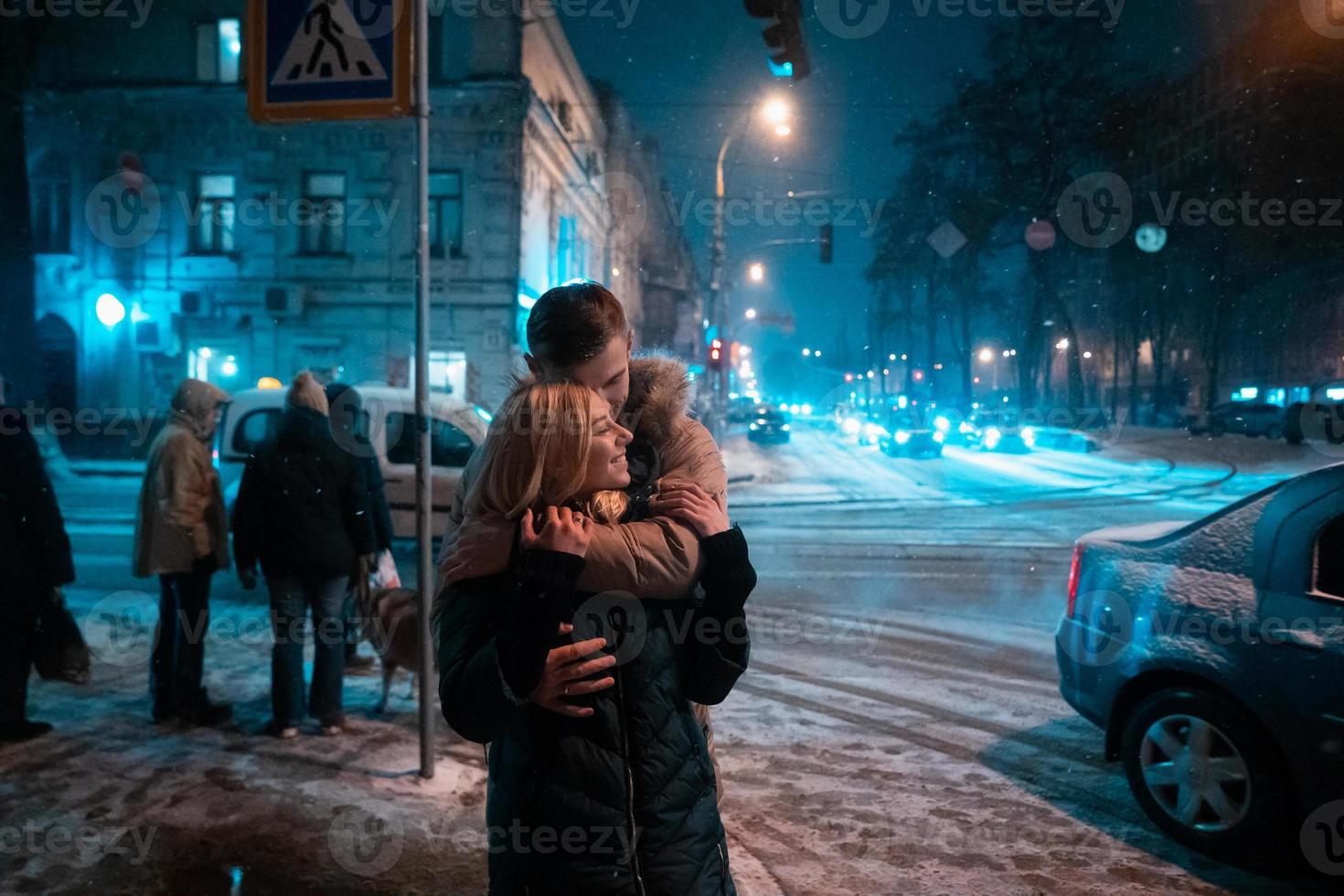 casal adulto jovem andando na calçada coberta de neve foto