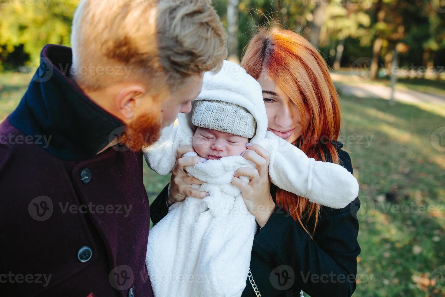 jovem família e filho recém-nascido no parque outono foto