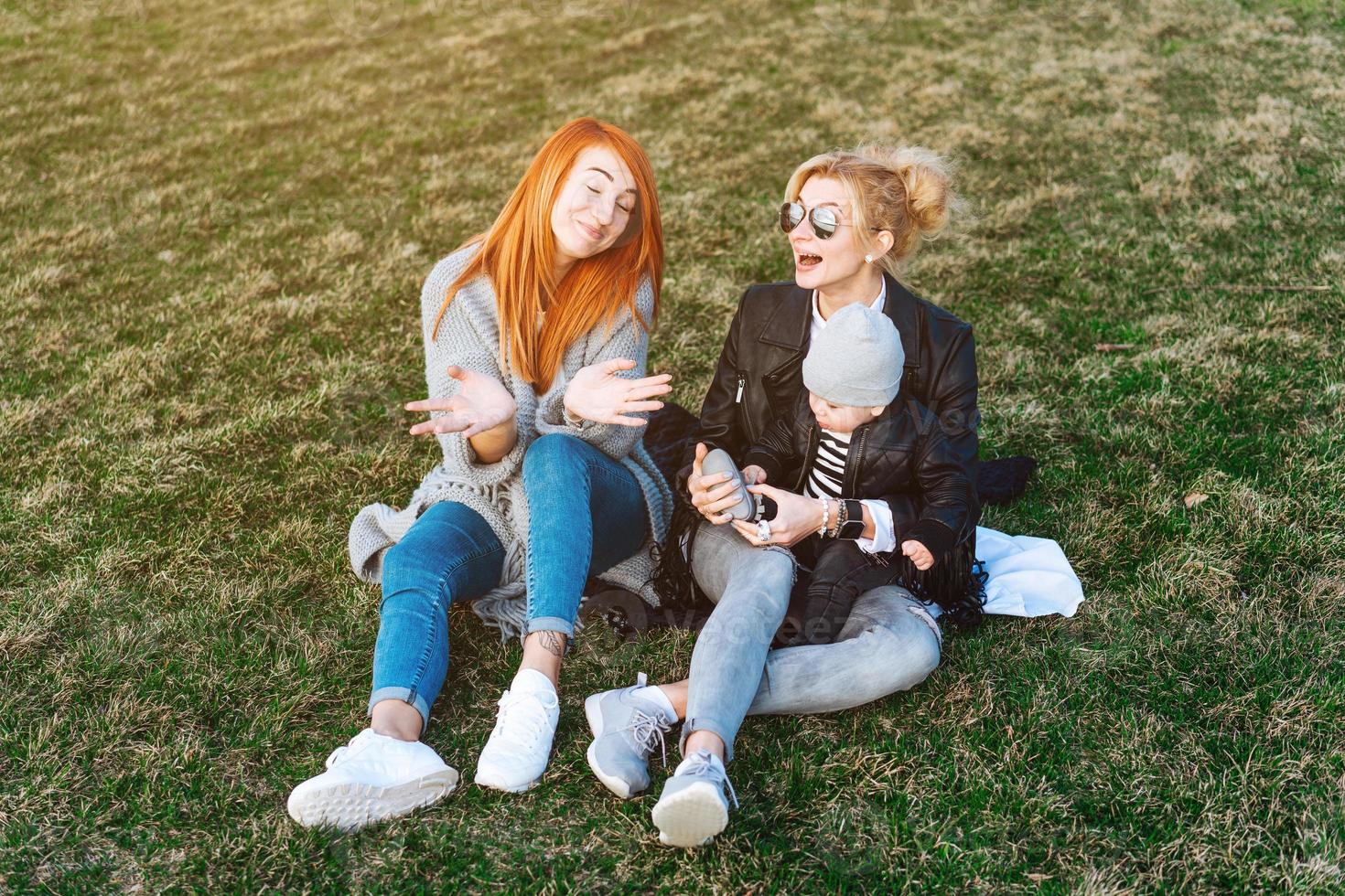 mãe e tia brincam com um menino no parque foto