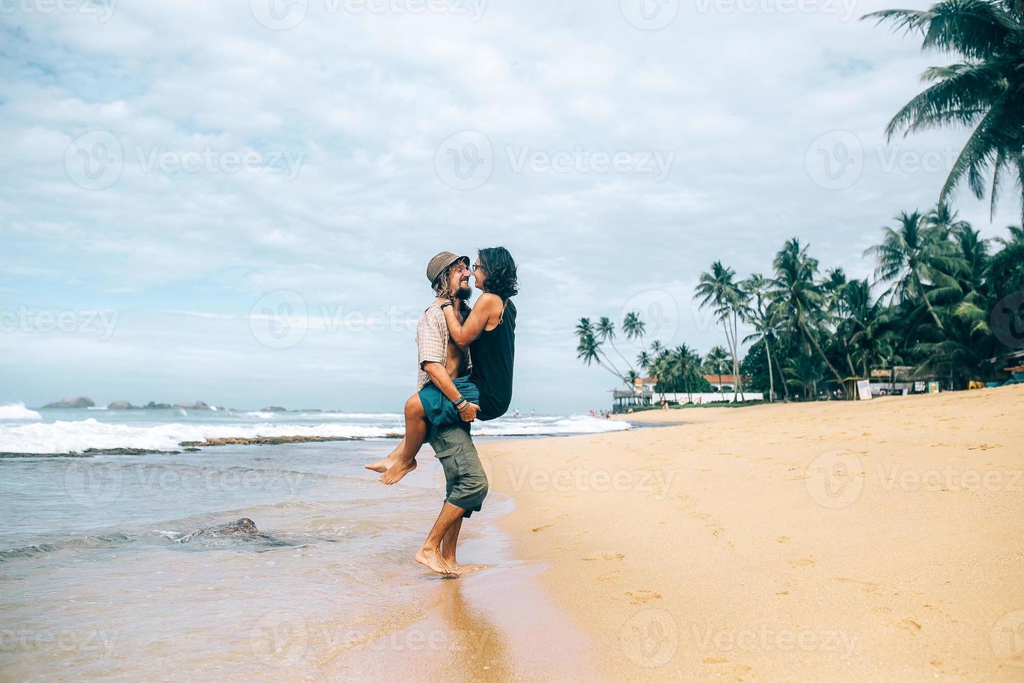 um cara e uma garota estão se beijando na praia foto