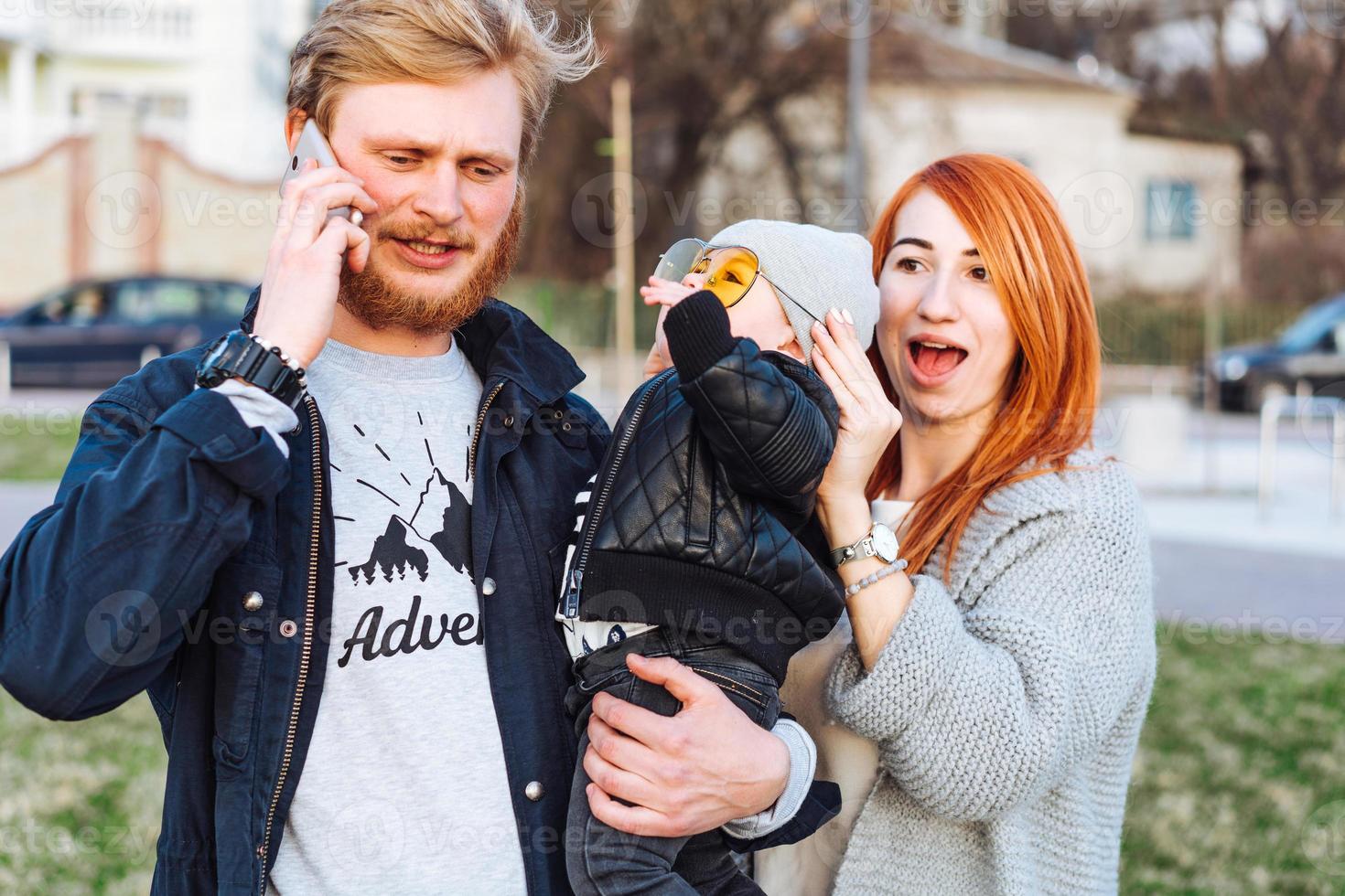 mãe feliz pai e filho abraçando no parque foto