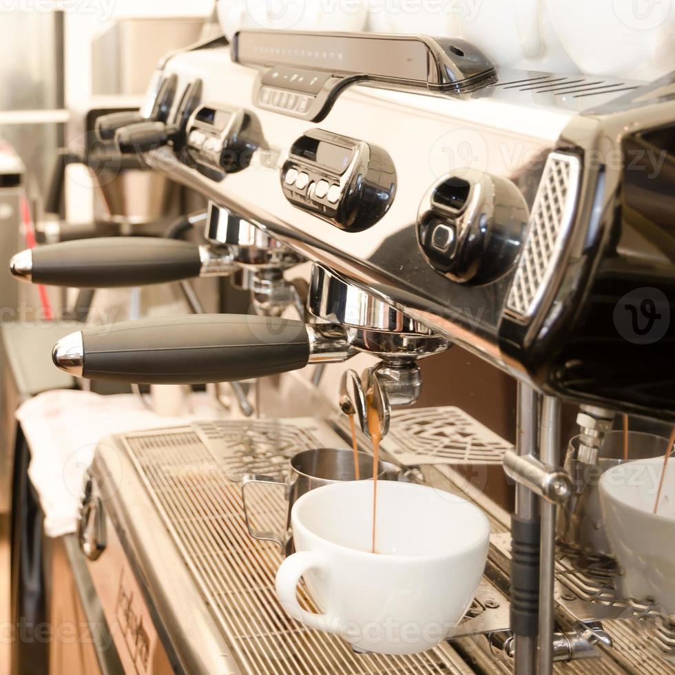 grande máquina de café expresso em uma cafeteria com uma caneca branca foto