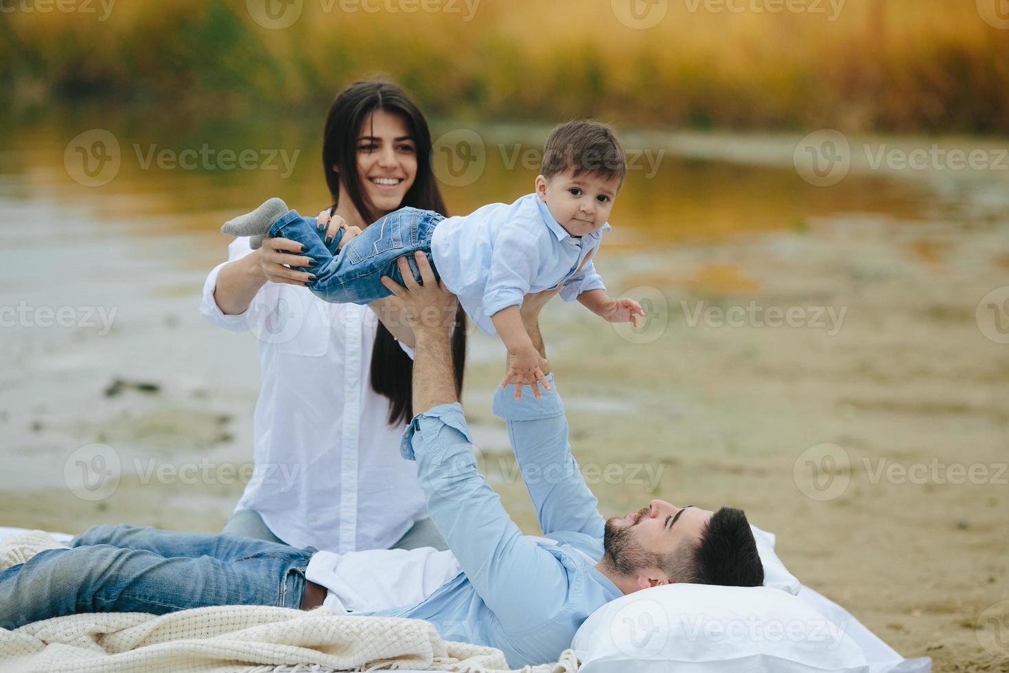 família jovem feliz relaxando juntos no lago foto