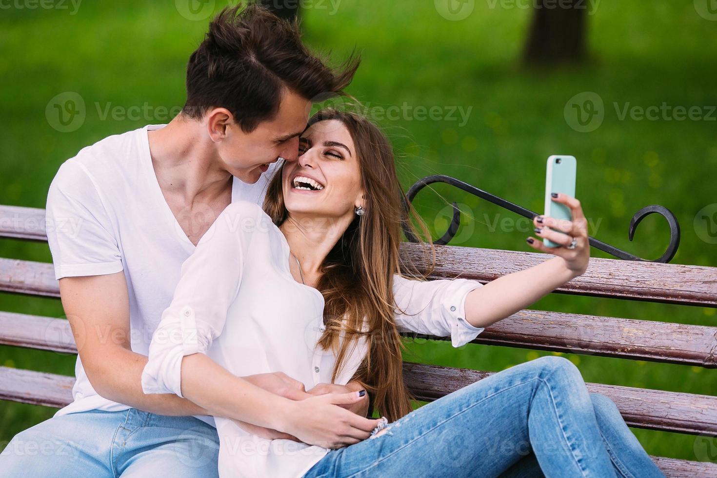 homem e mulher em um parque fazem selfie foto