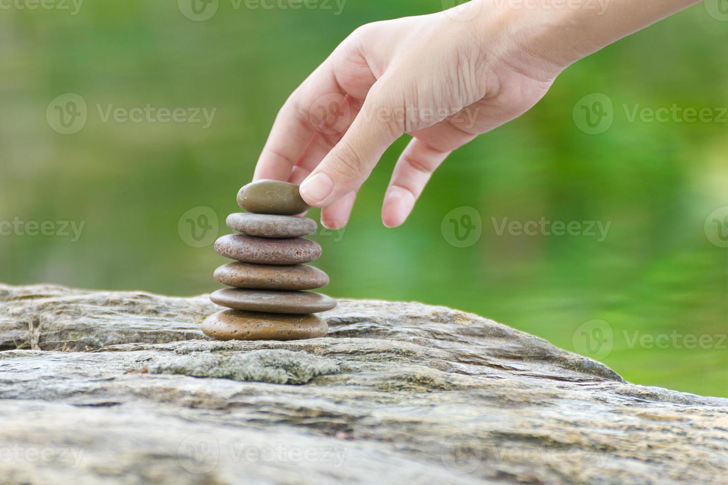 mão colocar pedra construindo uma pilha de pedras zen foto