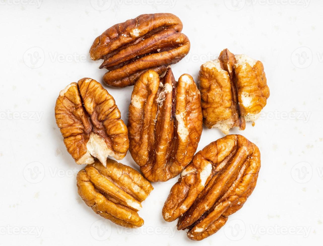 várias nozes pecan descascadas fecham em cinza foto