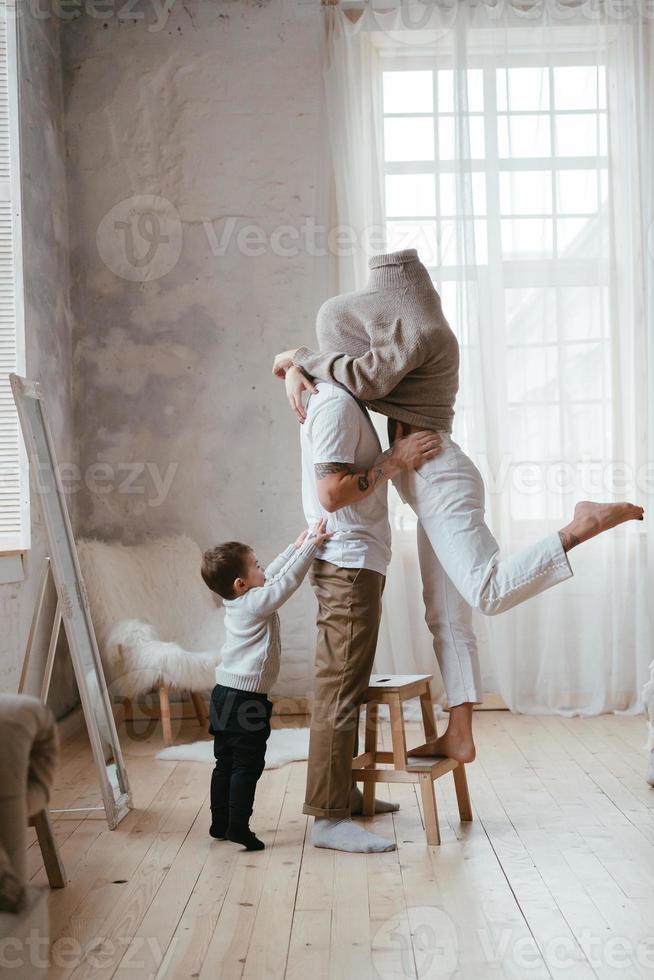 papai e mamãe brincam de esconde-esconde com o filho pequeno foto