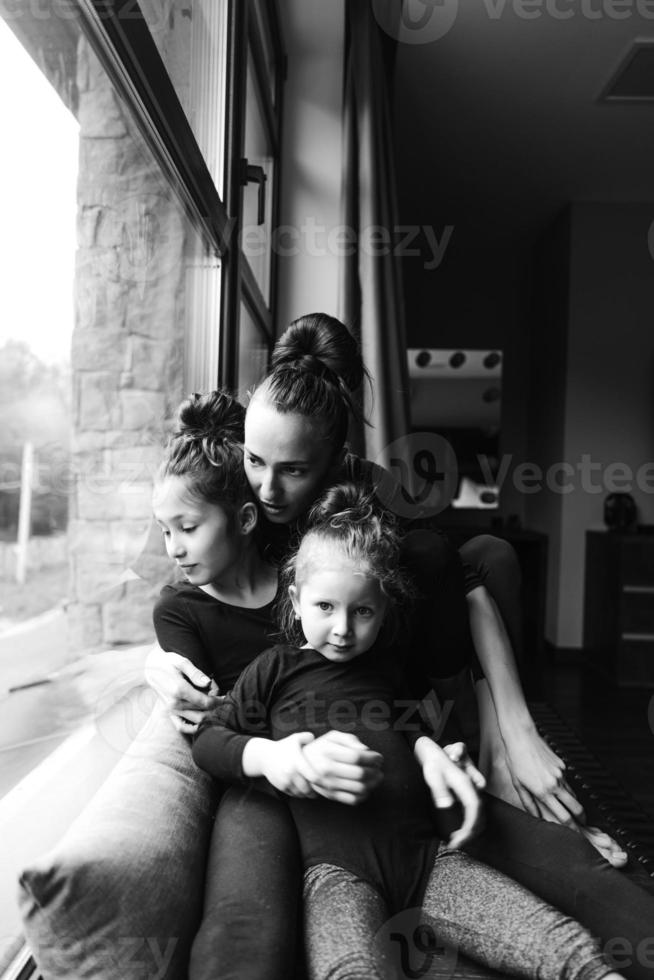 mãe e duas filhas juntas na janela foto