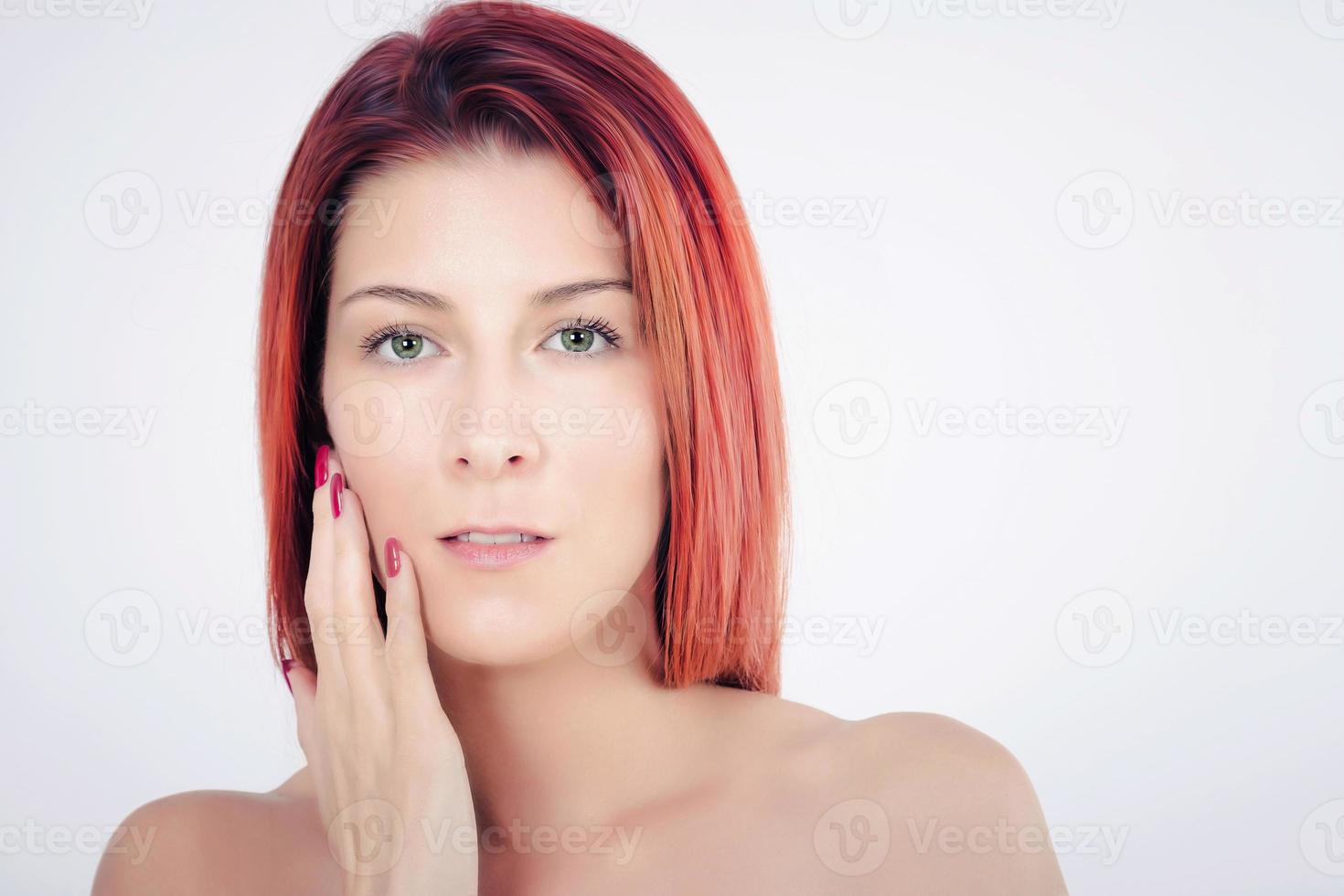 linda mulher tocando sua pele do rosto macio e limpo contra um fundo branco. foto