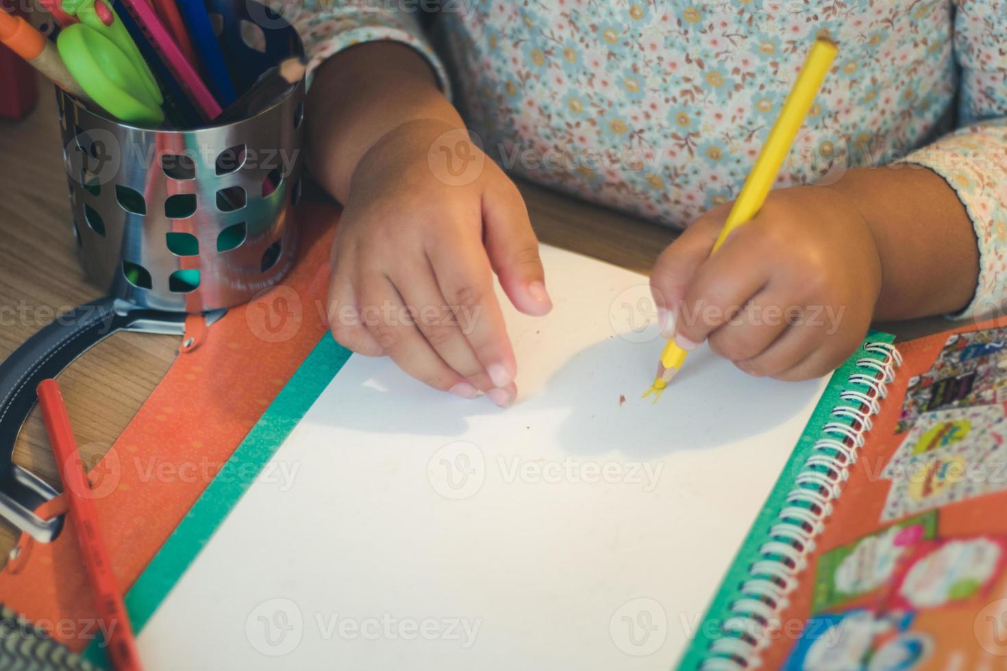 close-up de criança escrevendo em um pedaço de papel. foto