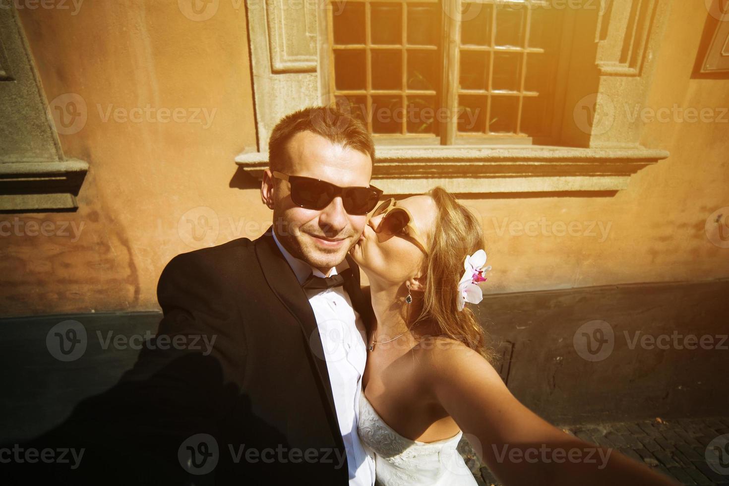 casal de noivos com óculos se alivia na câmera. foto