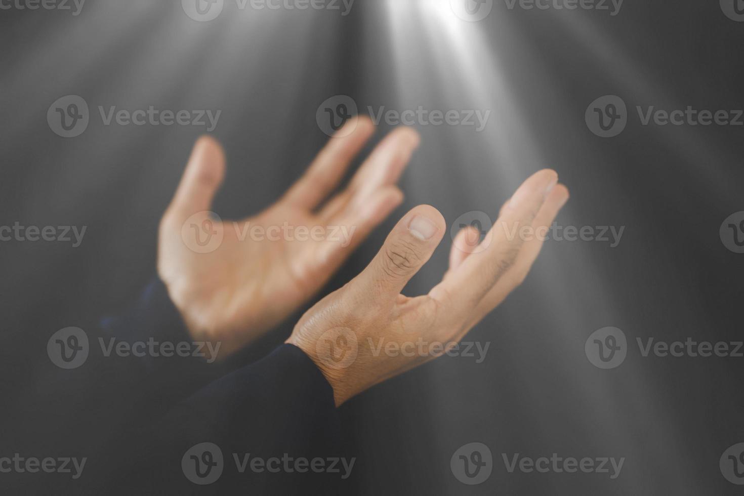 oração dobrada à mão a deus no escuro no conceito de igreja para fé, espiritualidade e religião, pessoa mulher orando na bíblia sagrada de manhã. mão de mulher católica cristã com adoração em fundo preto. foto