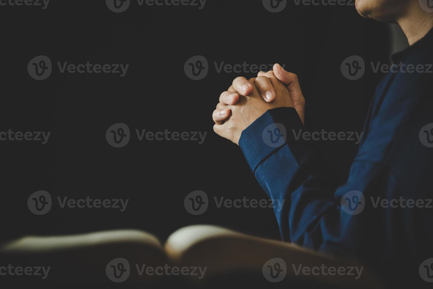 mão dobrada em oração a deus no livro da bíblia sagrada no conceito de igreja para fé, espiritualidade e religião, pessoa mulher orando na bíblia sagrada de manhã. mão de mulher católica cristã com adoração bíblica. foto