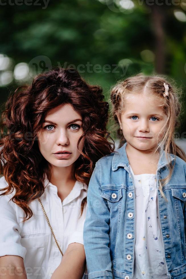 adorável jovem mãe e filha em dia ensolarado, família feliz foto