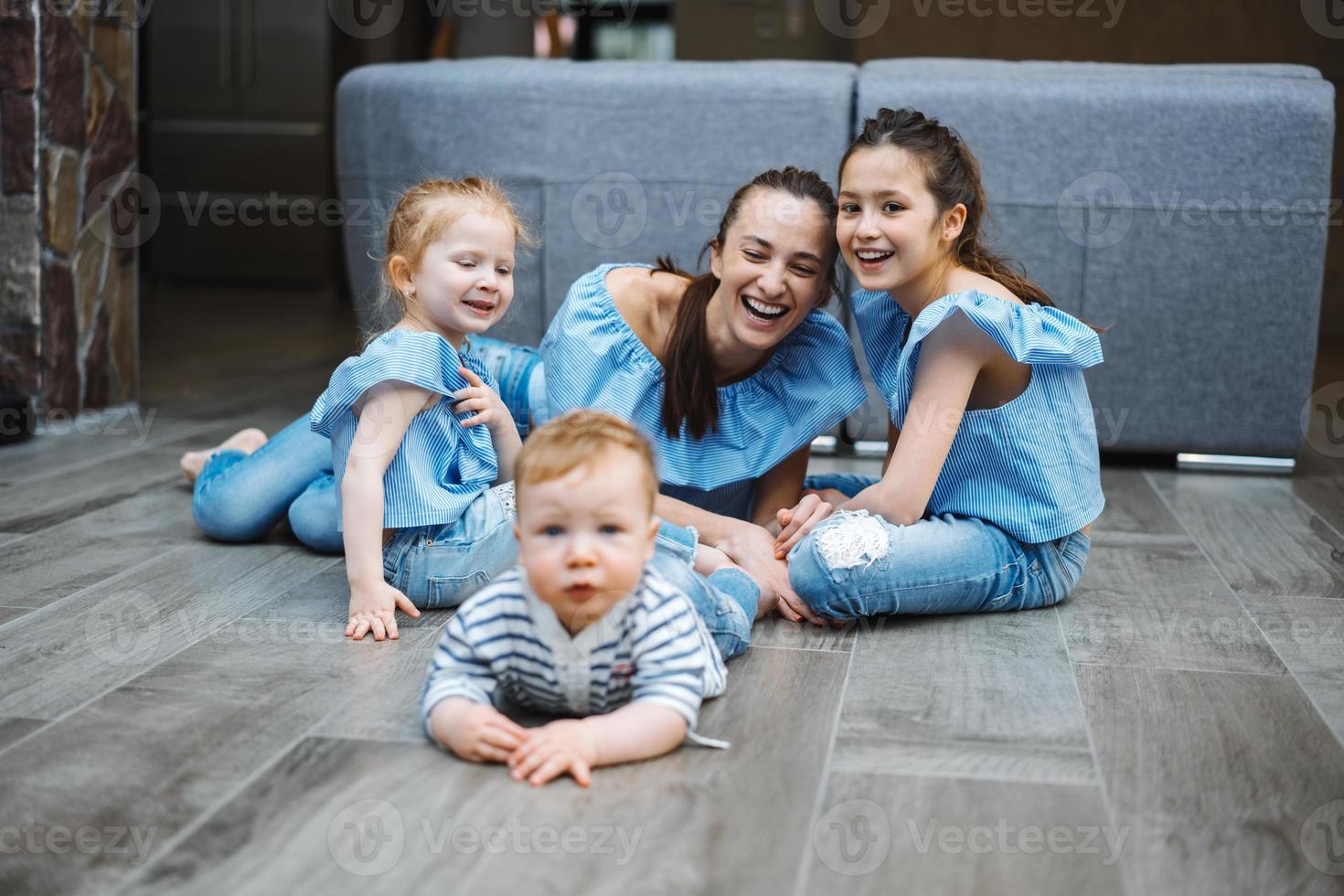 mãe, duas filhas e um filho pequeno no chão foto