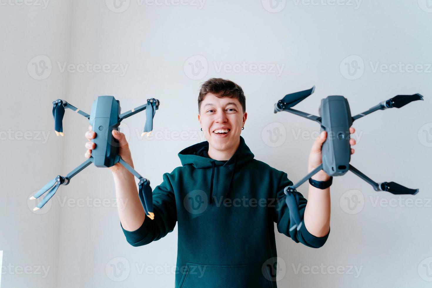 cara segura dois quadrocopters contra uma parede foto