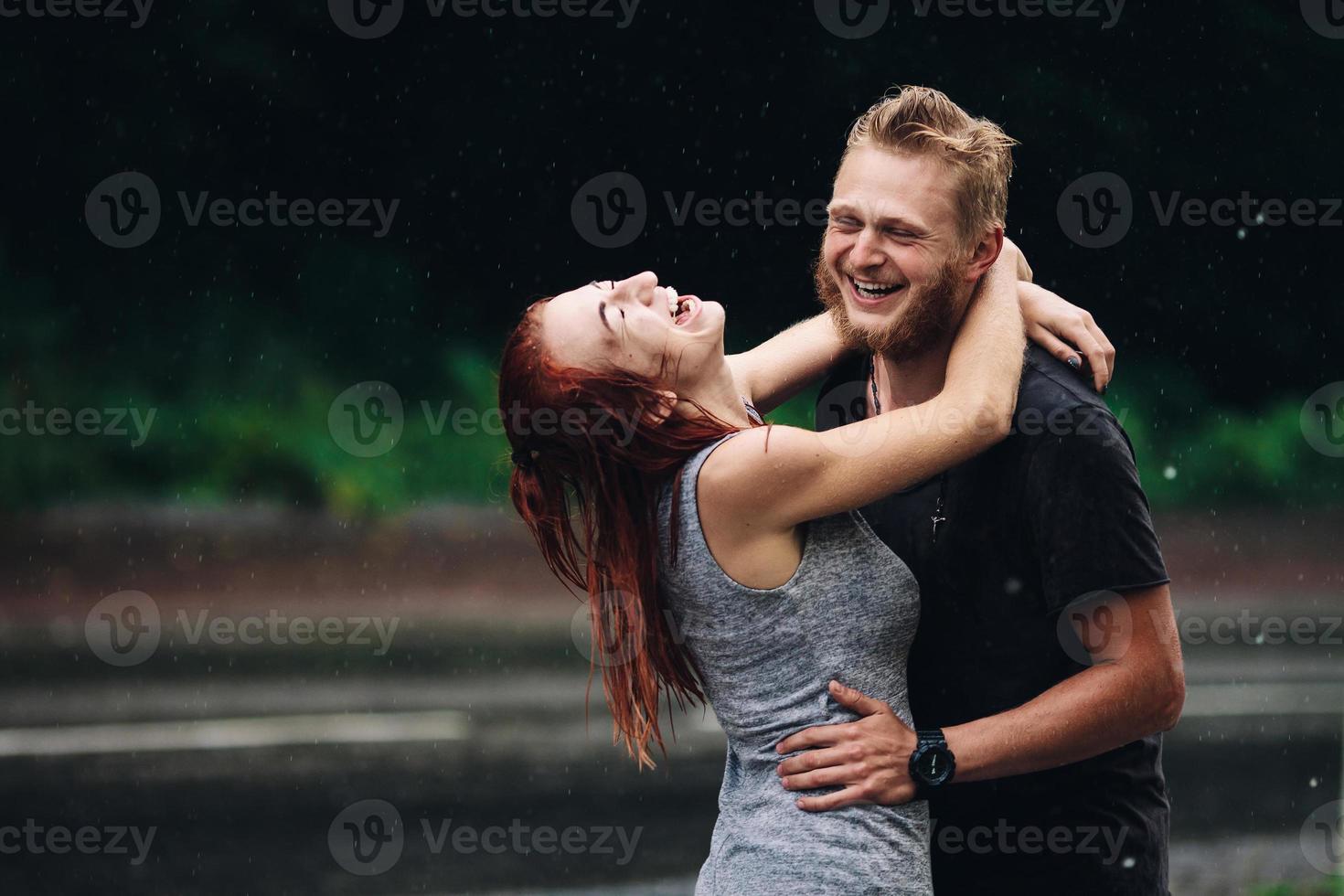 lindo casal abraçando na chuva foto