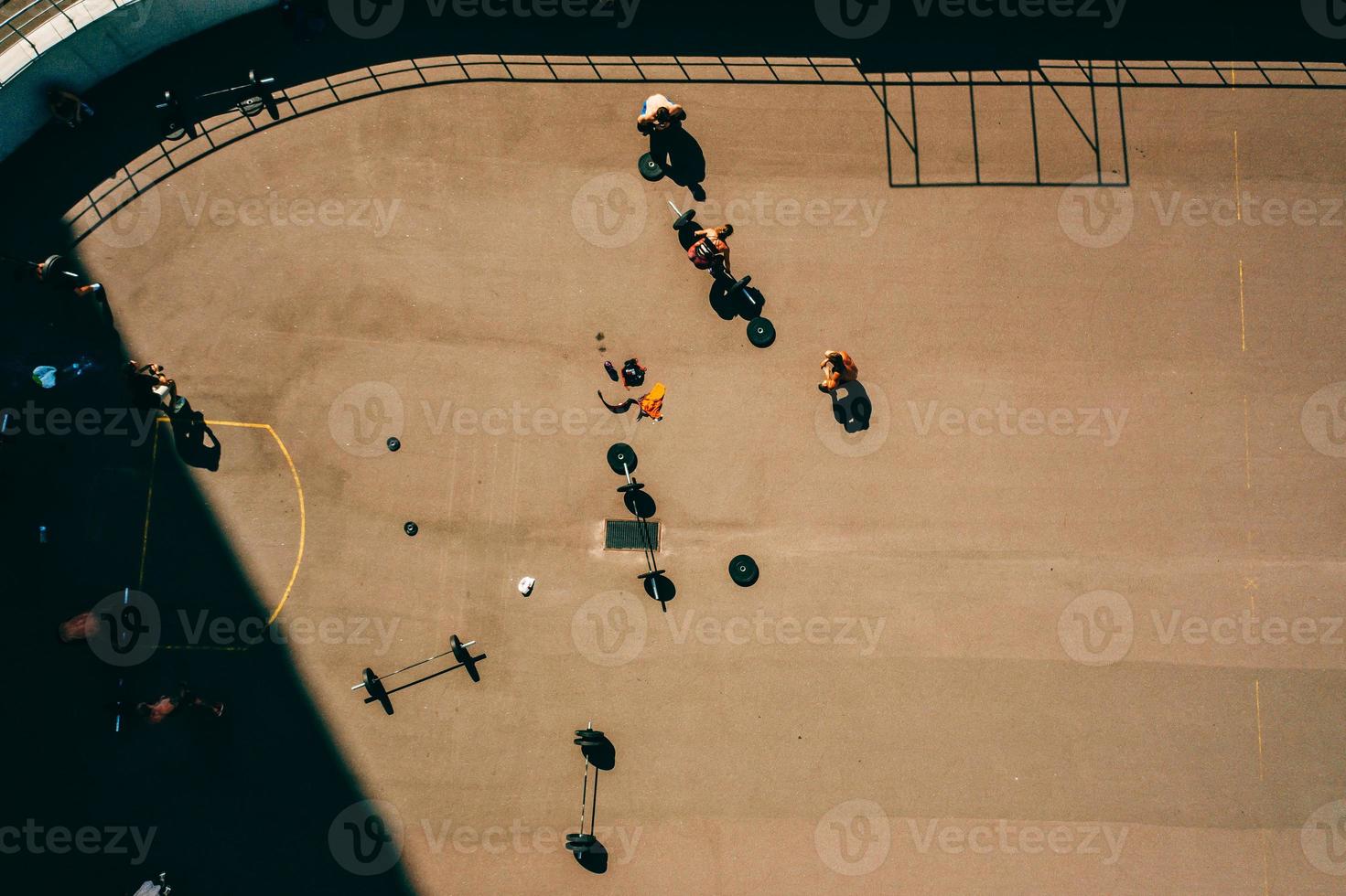 imagens aéreas de um campo de esportes, pessoas fazendo levantamento de peso foto