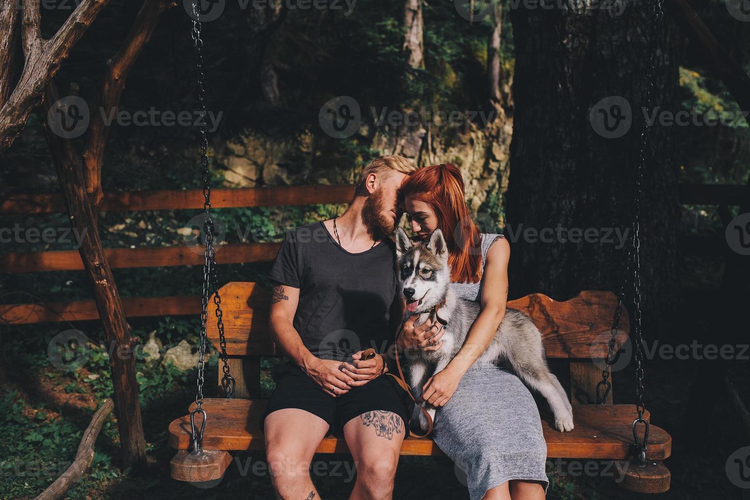 lindo casal junto com cachorro em um balanço foto