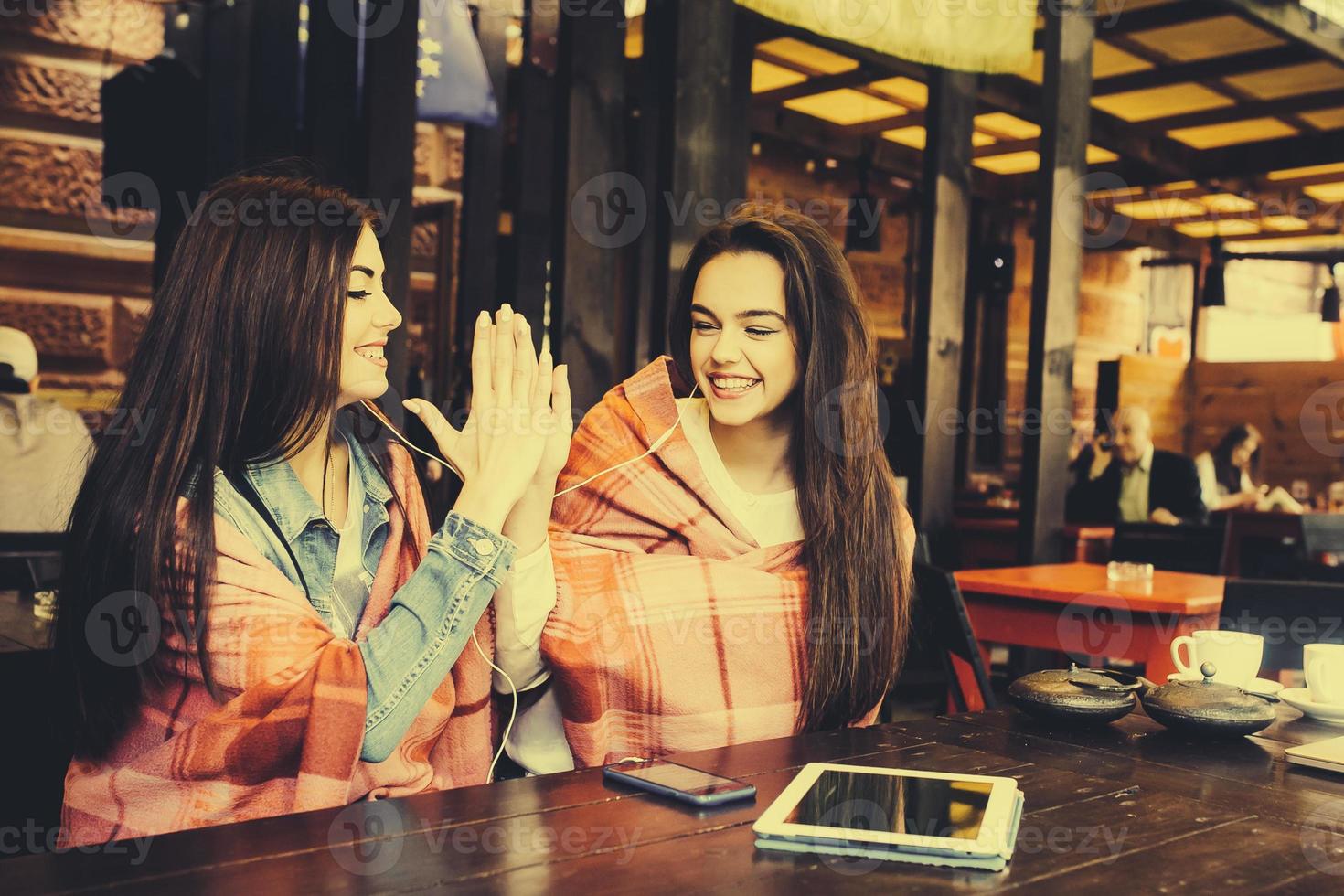 duas meninas jovens e bonitas se divertindo no café foto