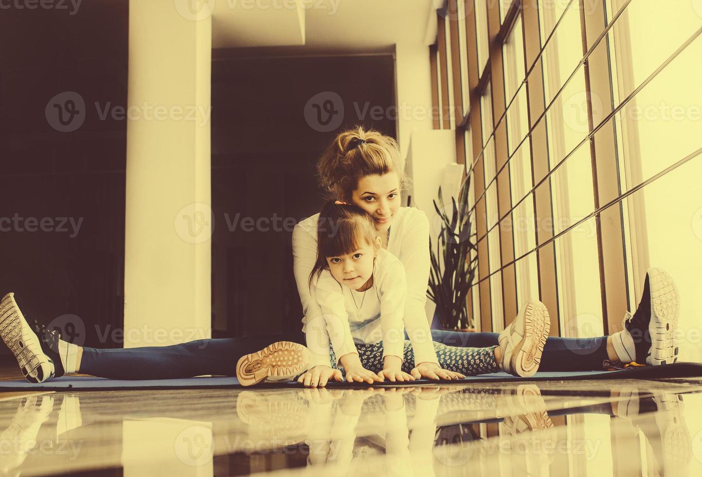 mãe e filha se abraçam e se alongam na academia foto