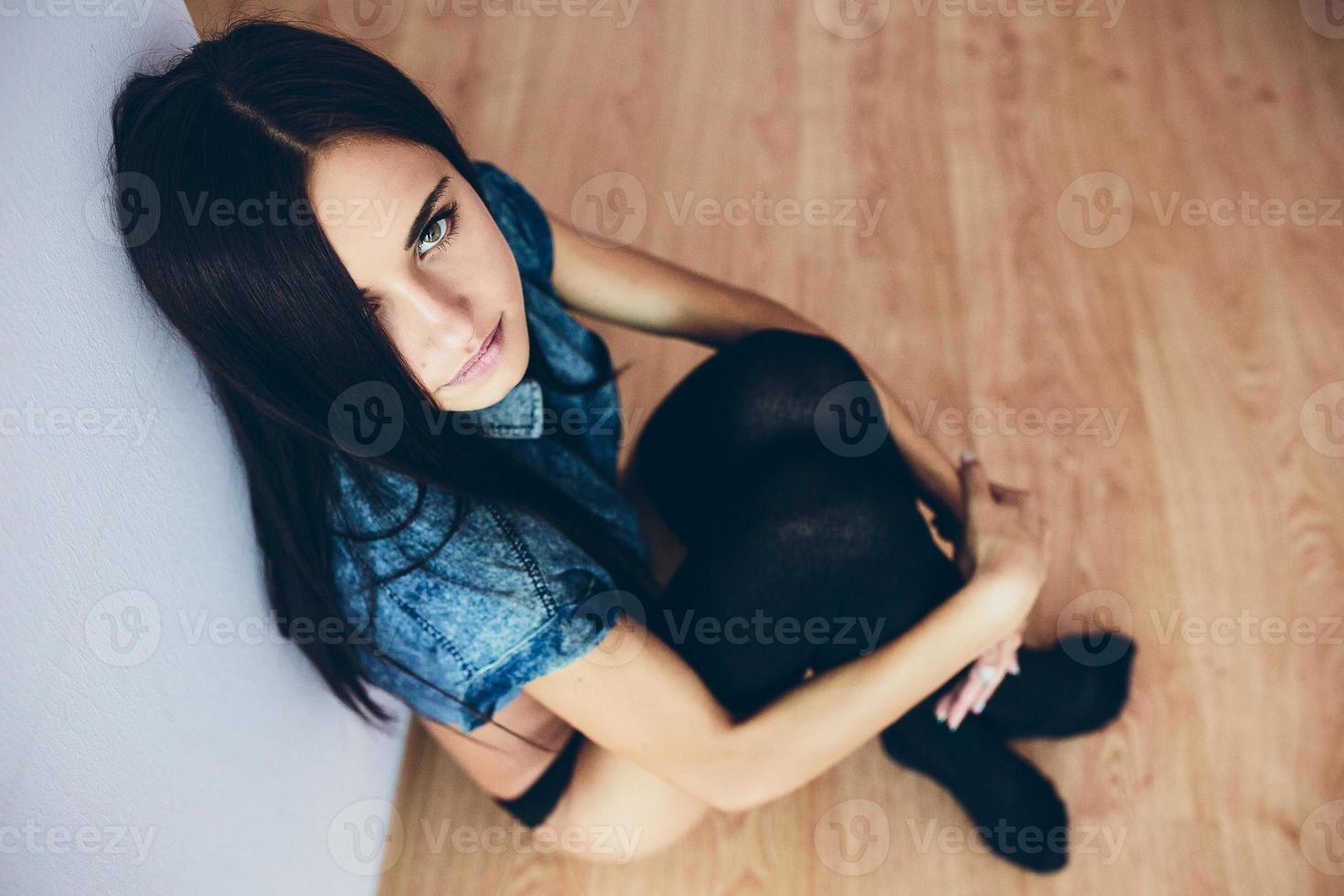 linda jovem posando sentada no chão foto