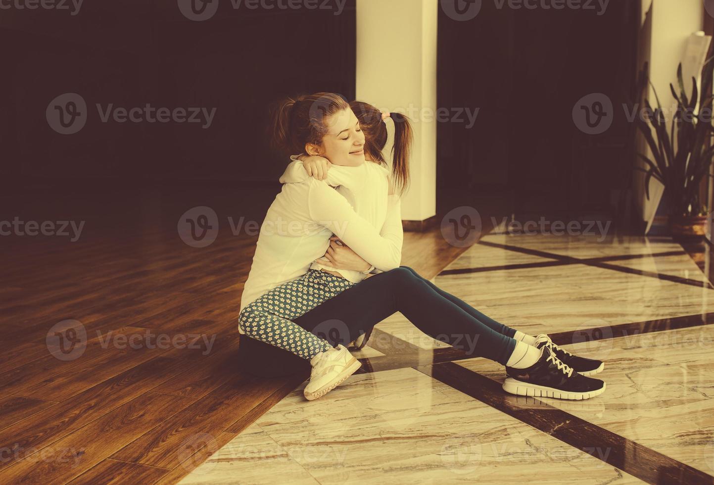 mãe e filha se abraçando na academia foto