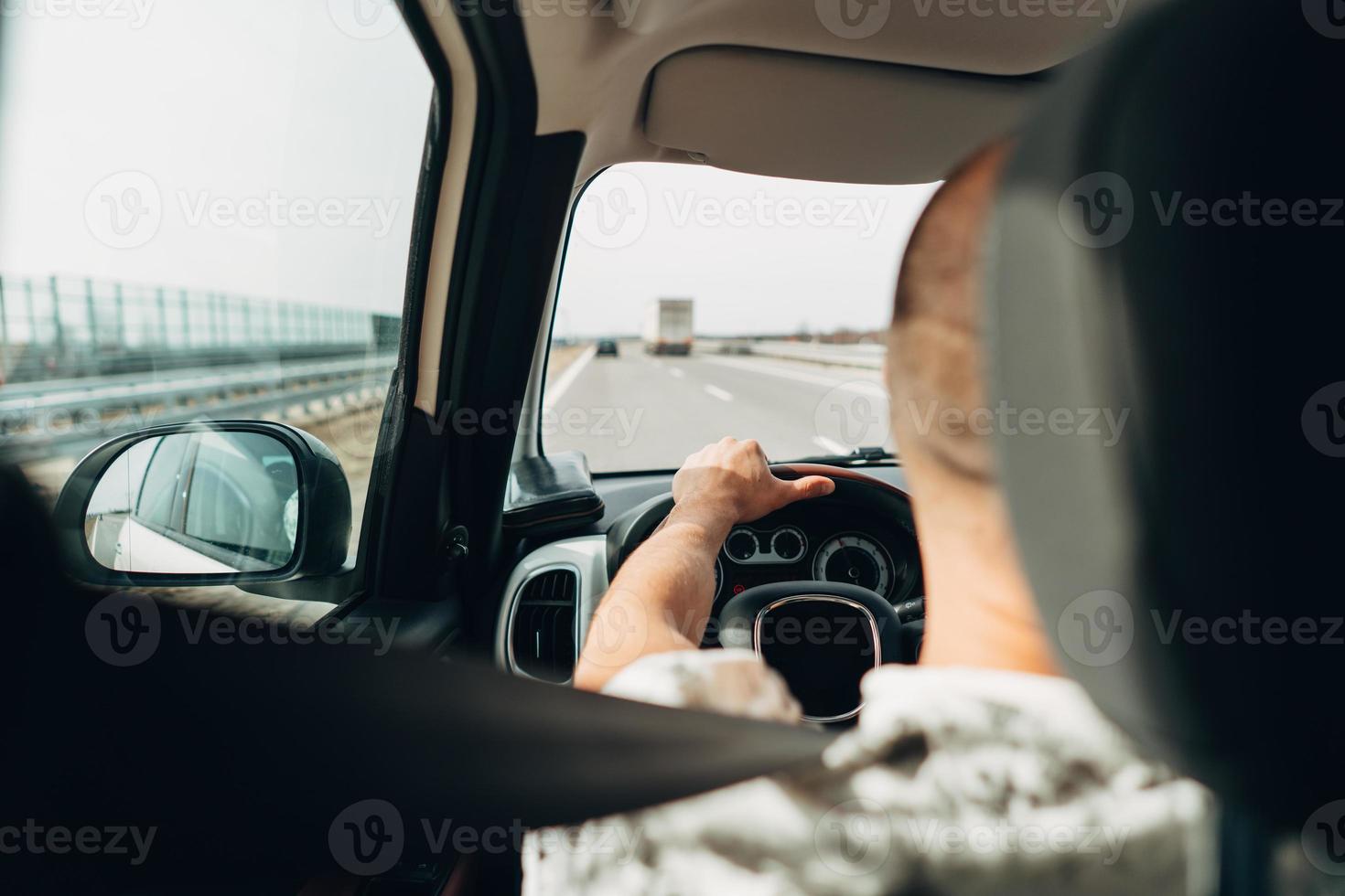 o homem no carro viajando na estrada foto