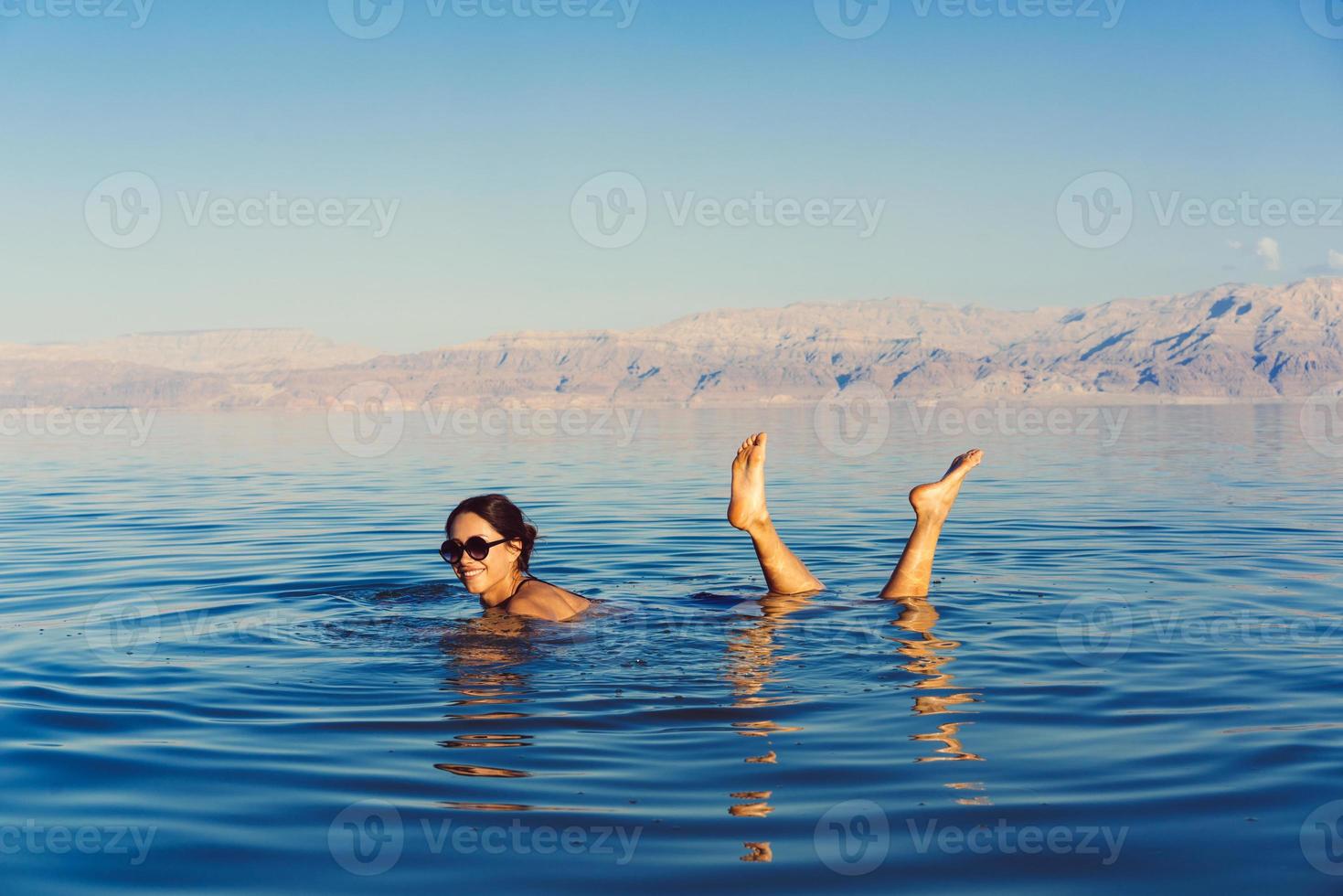 garota está relaxando e nadando na água foto
