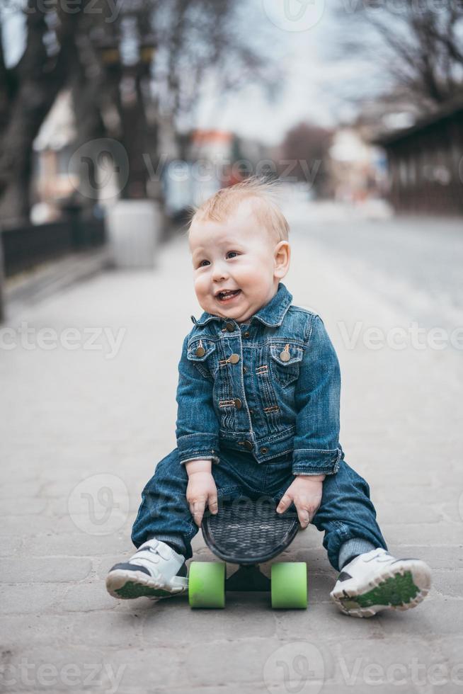 menino engraçado com skate na rua foto