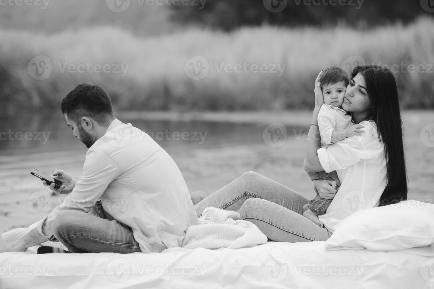 família jovem feliz relaxando juntos no lago foto