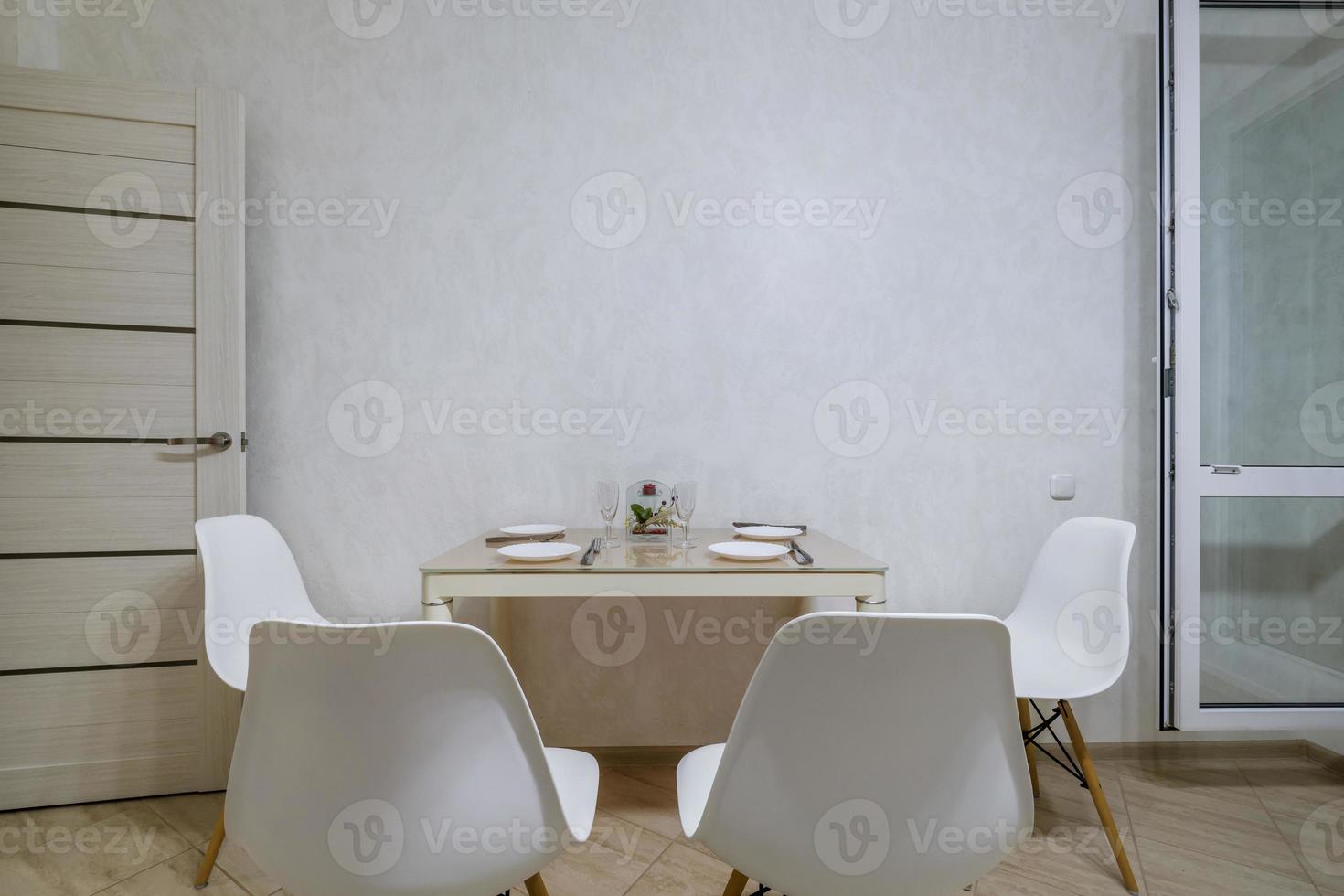 cadeiras confortáveis e mesa com flores no interior da moderna sala de estar ou cozinha foto