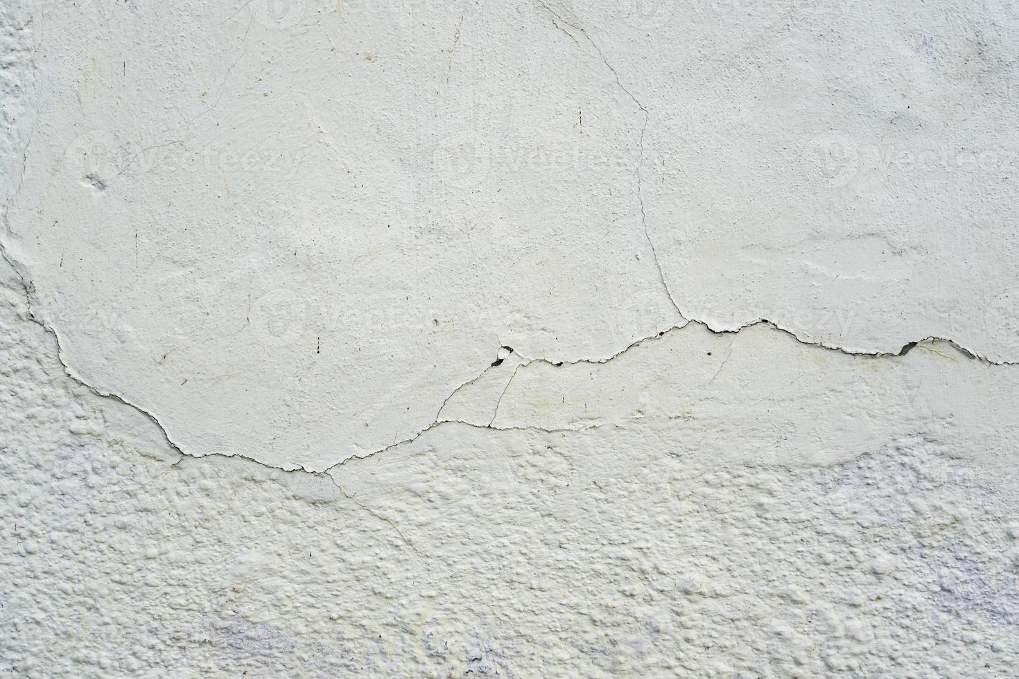 superfície da parede cinza de concreto em rachaduras foto