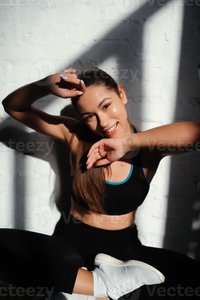 retrato de mulher bonita. garota em forma feliz em roupas esportivas rindo foto