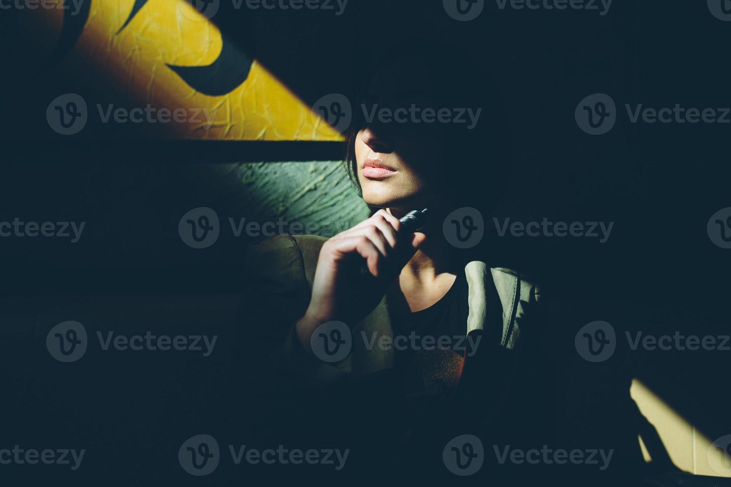 menina senta-se e fuma cigarro eletrônico foto