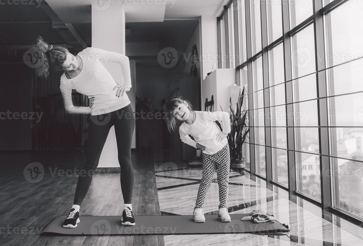 duas garotas de diferentes idades fazendo yoga foto