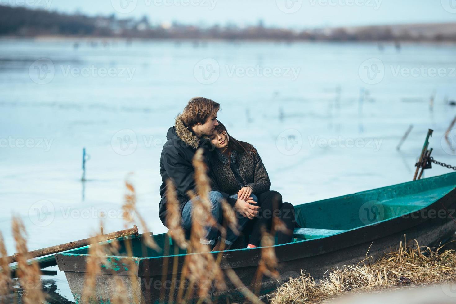 jovem casal lindo no gelo de um lago congelado foto