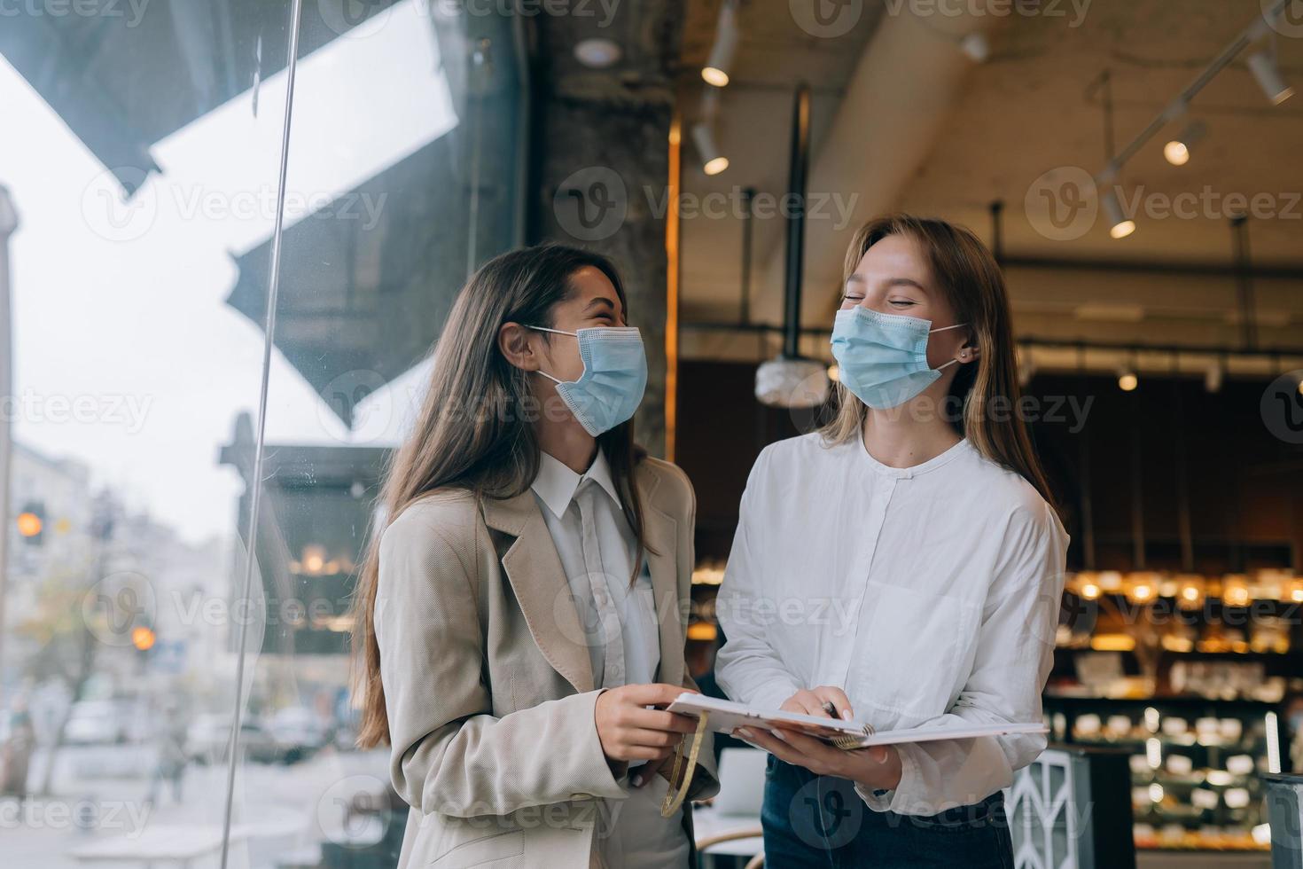 duas empresárias com suas máscaras, debatendo diferentes pontos de vista sobre o trabalho foto