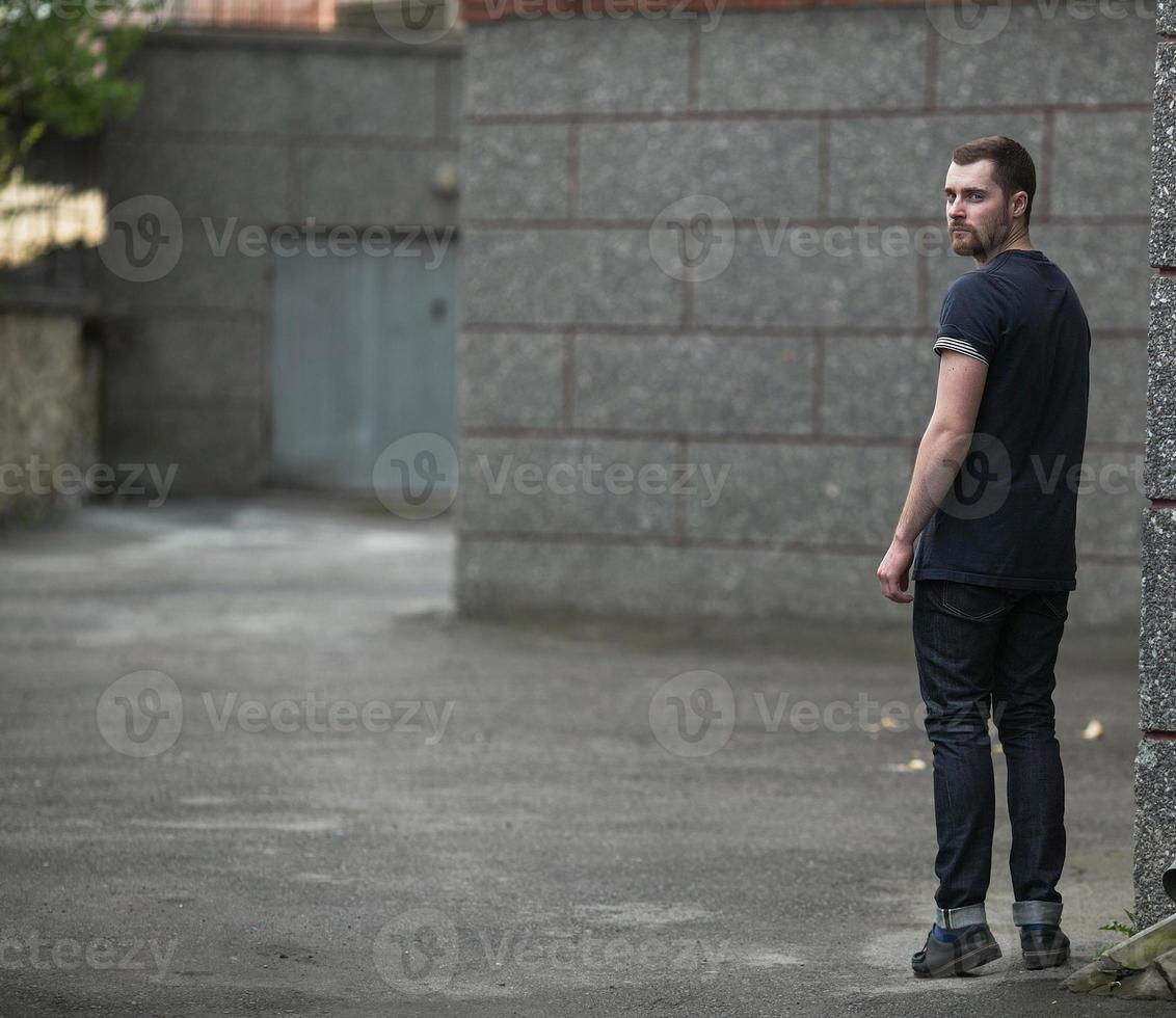 o homem com botas autênticas e jeans selvedge em um fundo da cidade velha foto