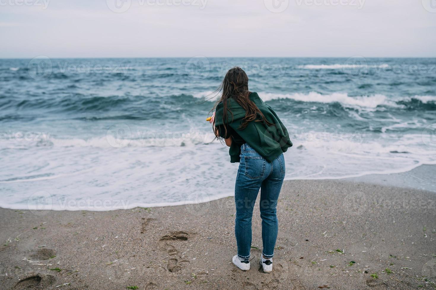 woma atira em um smartphone as ondas do mar foto