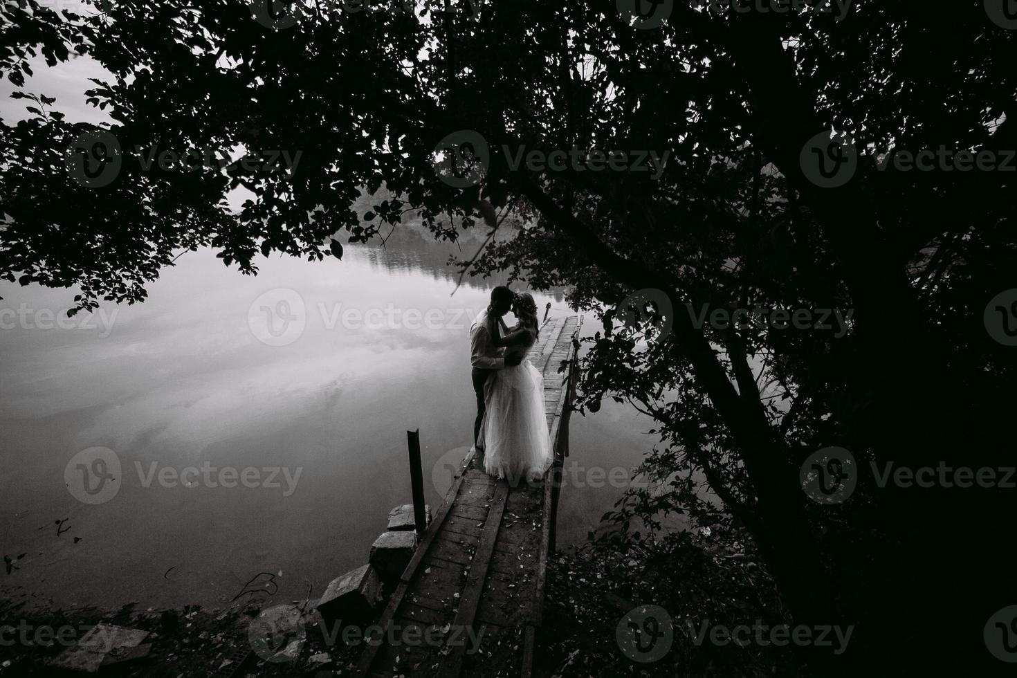 casal de noivos no velho cais de madeira foto