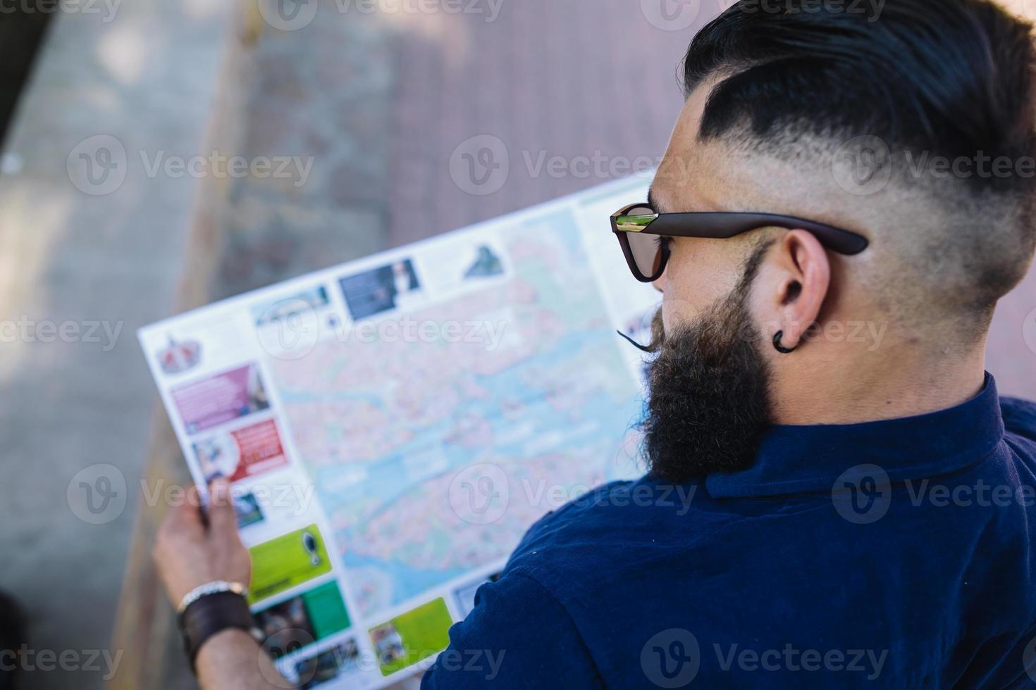 homem barbudo olhando para um mapa foto