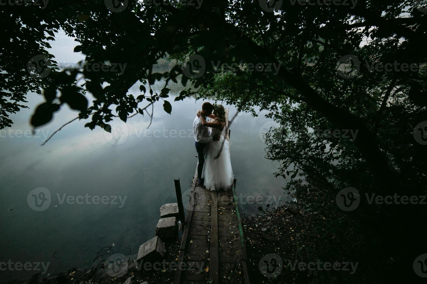 casal de noivos no velho cais de madeira foto