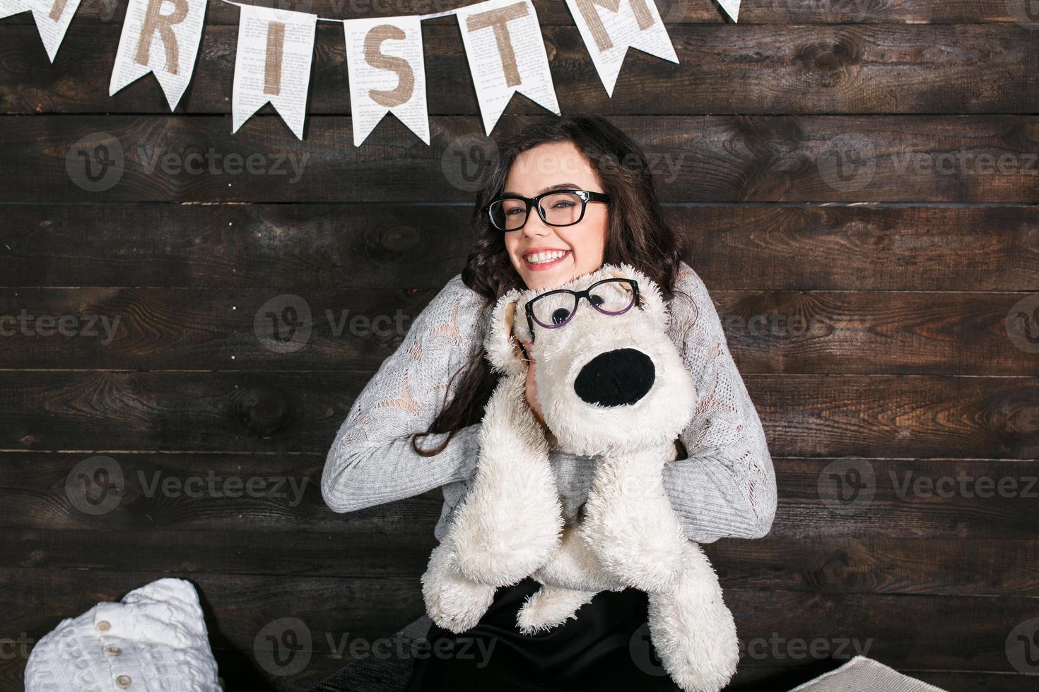 menina bonitinha abraçando um brinquedo fofo. fundo de natal foto